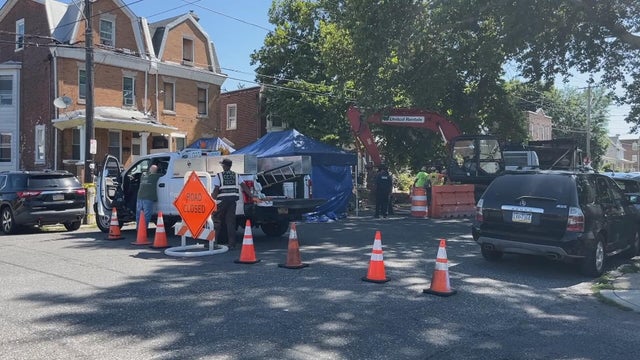 Workers and construction vehicles behind a "road closed" sign on Chew Avenue in Olney as the investigation continues 