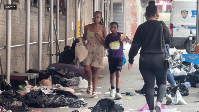 Mom and child walk past trash and people experiencing homelessness 