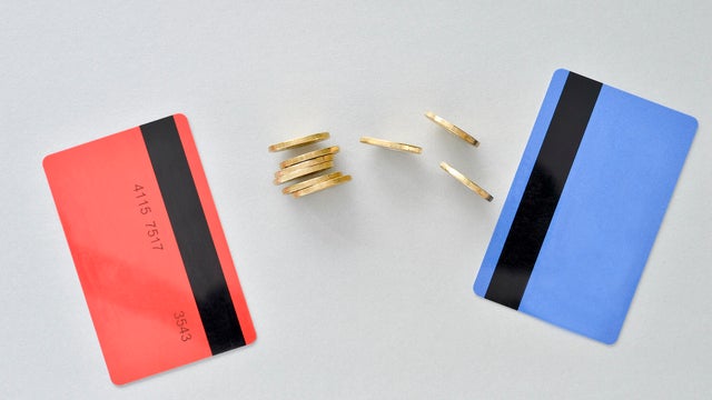 Bank cards are in the colors of living coral and blue with shiny yellow coins symbolizing the electronic exchange of money 