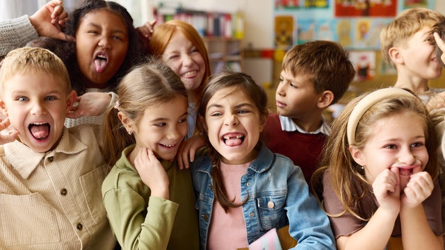 Playful school kids making faces in the classroom. 