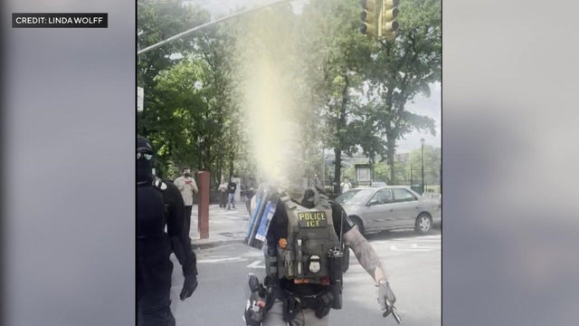 ICE agent spraying pepper spray toward camera 