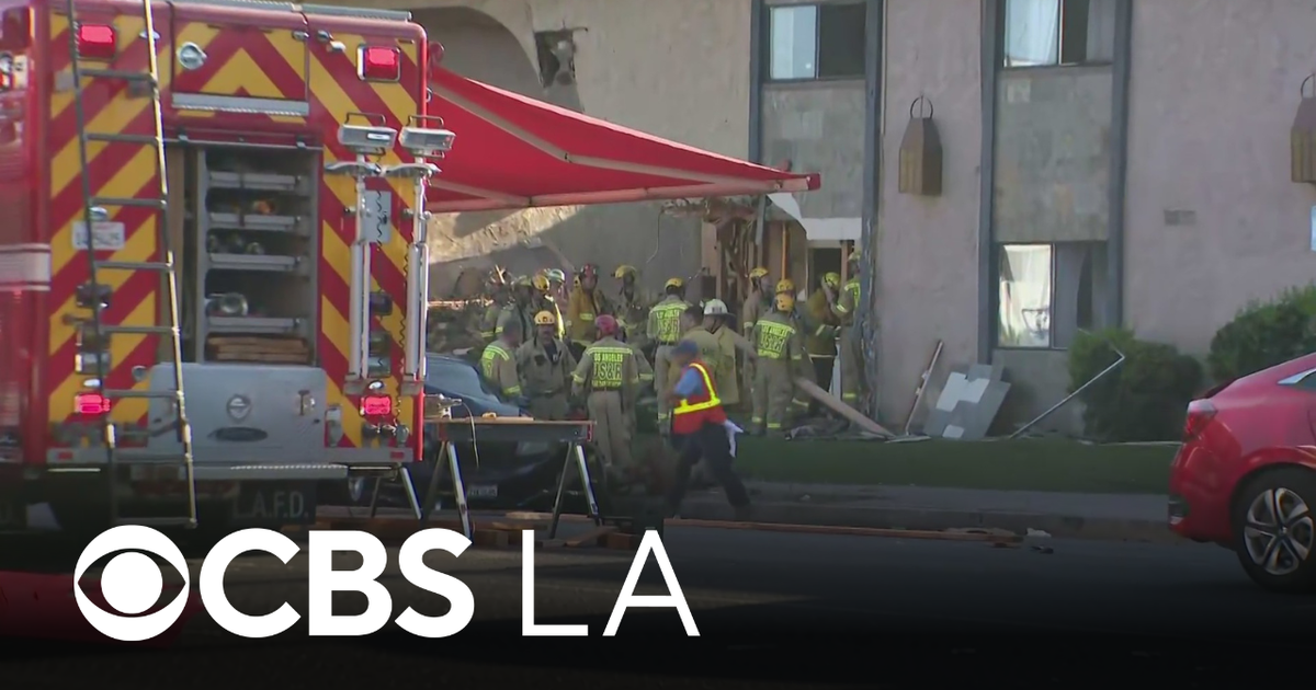 2 injured after big rig hauling cars crashes into apartment building in ...