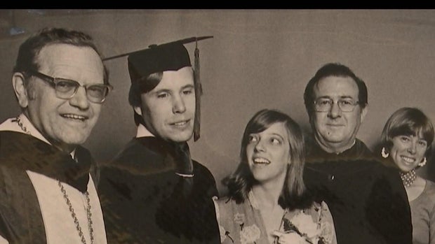 A group of five people pose at a graduation at Temple University in 1976. Among them are David Hartman, the first blind graduate of an American medical school. He is wearing a graduation gown and a cap with a tassel.