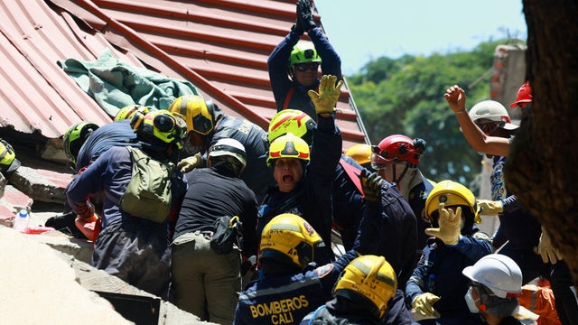 Firefighters react as they rescue a person following an earthquake, in Cali, Colombia, Aug. 11, 2026. 