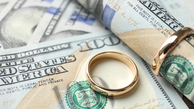 Gold wedding rings and dollar banknotes, closeup 