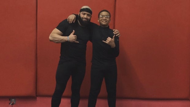 Jeremiah Delgado and his dad pose for a photo in a gym