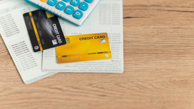 Credit cards and financial documents are placed on the desk. 