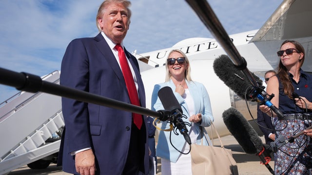 President Trump speaks with reporters as White House press secretary Karoline Leavitt listens before boarding Air Force One on Friday, Aug. 21, 2026. 