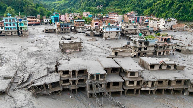 An aerial view shows houses deluged in sludge after flash flooding at Devighat in Nepal's Nuwakot district Aug. 27, 2026. 
