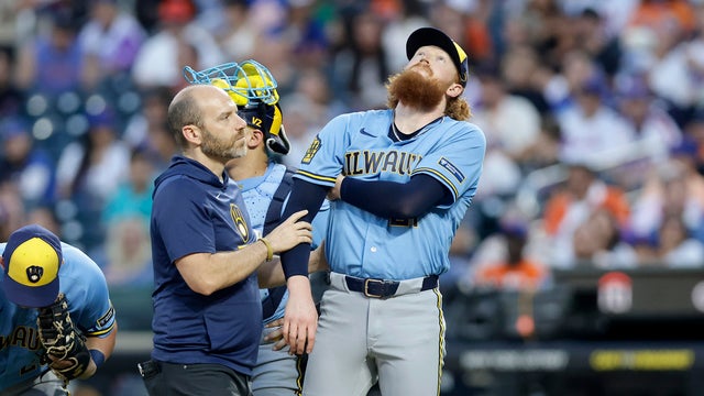 A trainer checks on Dustin May #21 of the Milwaukee Brewers after he was hit with a batted ball during the first inning against the New York Mets at Citi Field on August 26, 2026 in New York City. 