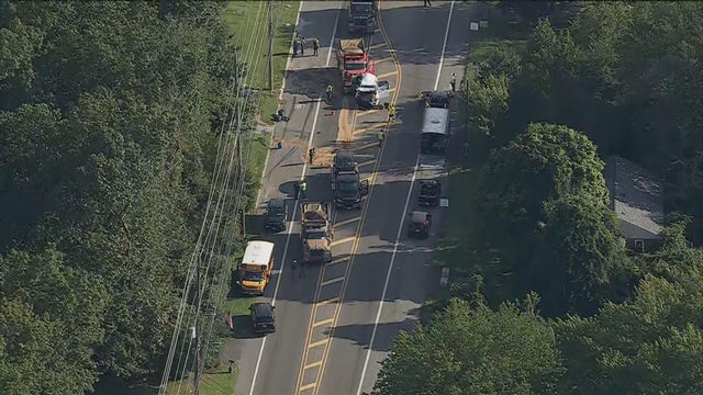 Chopper image of a crash scene, a dump truck, a car and a school bus are seen in addition to emergency vehicles and crews 