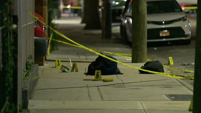 Bags on sidewalk behind crime scene tape 