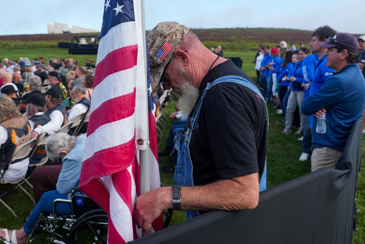 A man looks down as he stands next to a U.S. flag during a ceremony held at the Flight 93 National Memorial in Stonycreek Township, Pennsylvania, near Shanksvil