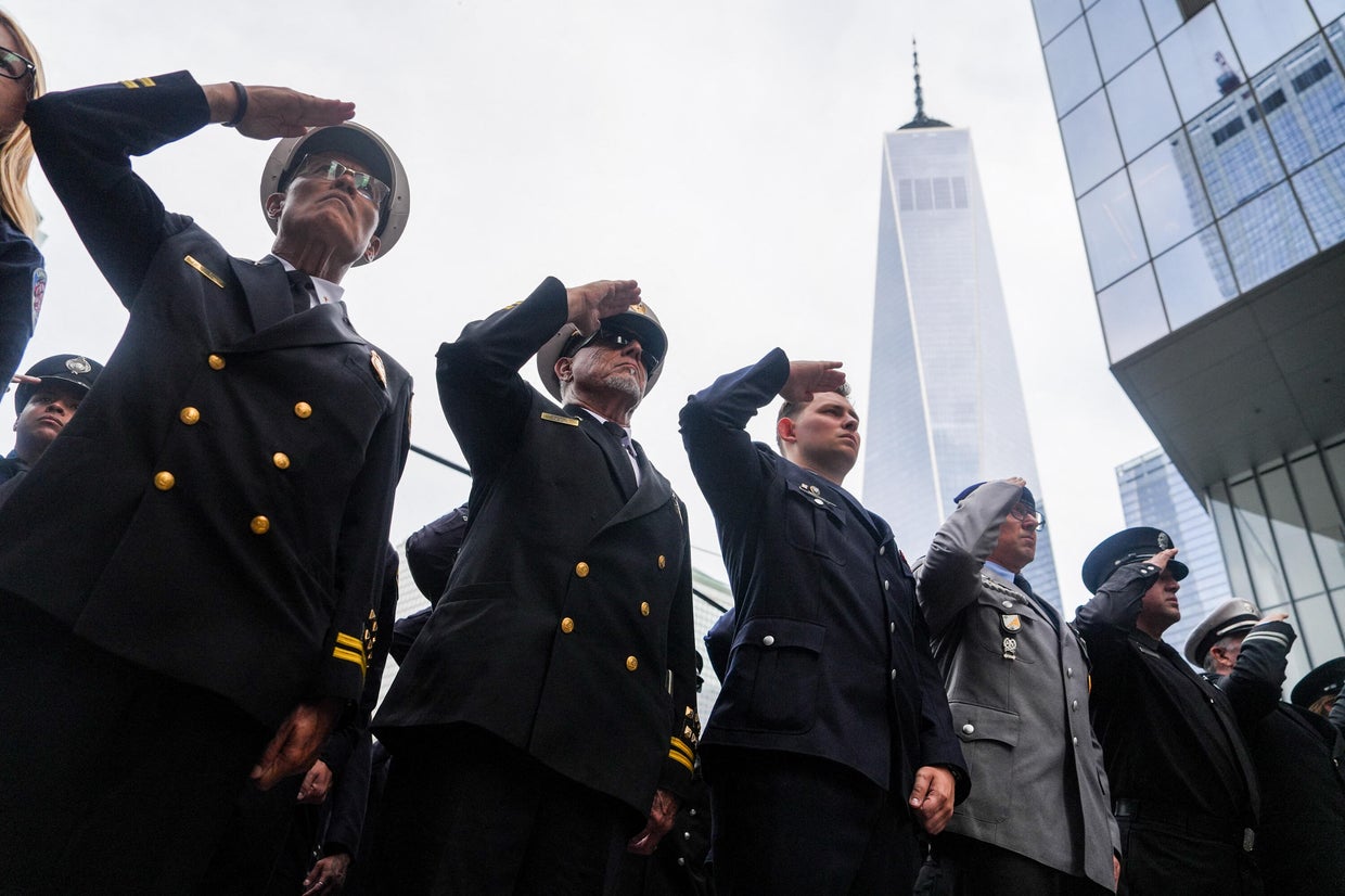 Firefighters salute during a moment of silence outside the FDNY