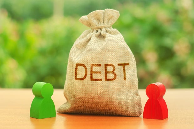 A bag with the inscription DEBT stands between two figures of people. Unclosed obligations between two persons, financial or moral debt. refusal to return debts. redemption and restructuring 
