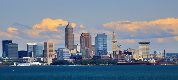 Cleveland Ohio downtown skyline over Lake Erie under blue sky with colorful clouds