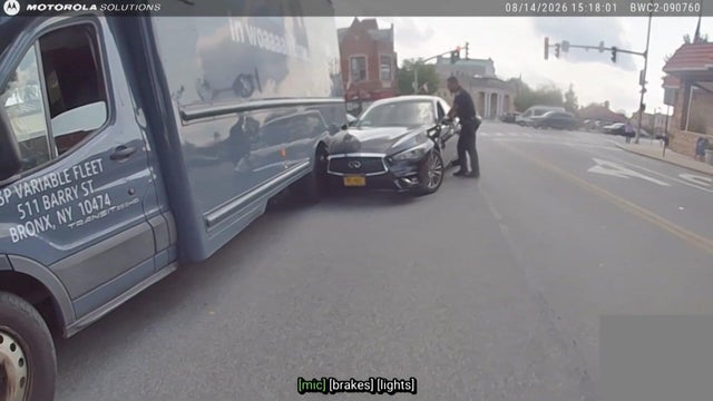 A police officer speaks to a driver in a sedan that has crashed into an Amazon truck 