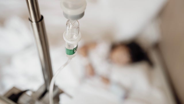 Close-Up View of Saline Drip Hanging on Metal Hook in Hospital Setting - Medical Equipment for Life-Saving Intravenous Therapy 