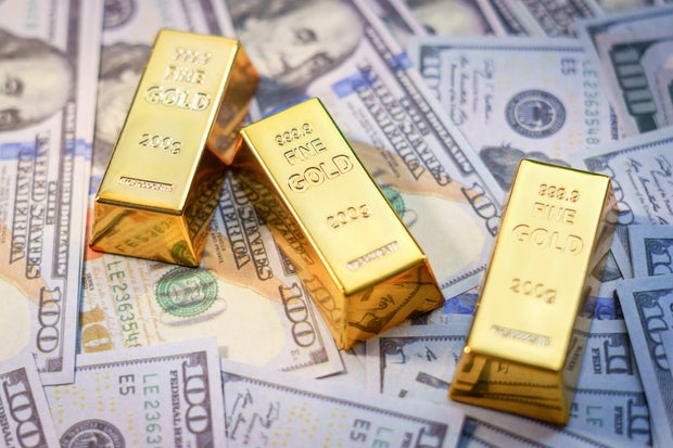 Gold bars laying on United States dollars 