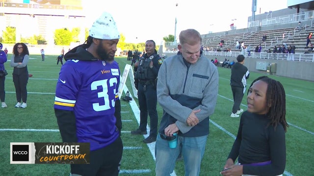 A young football player gets guidance from a pro
