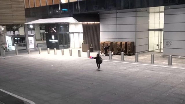 A person pointing a gun runs away from the Four Seasons Hotel in Philadelphia after an apparent robbery 