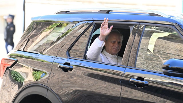 Pope Leo XIV waves from a car window as he heads to the hospital for lung cancer surgery in October 2026 