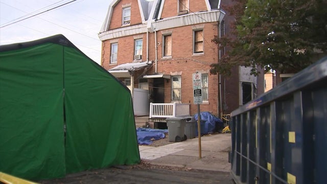 A green tent is outside the boarded up house on the 400 block of West Chew Avenue in Olney 