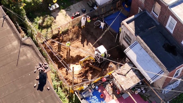 Overhead look at investigators digging up the backyard of the house in Olney