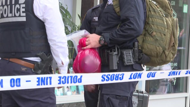 NYPD officer holding evidence bags 