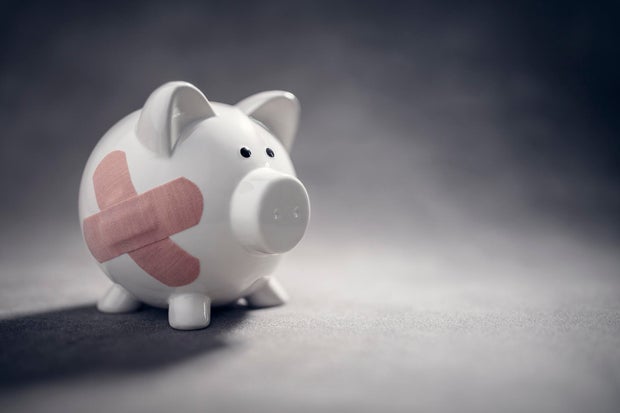 Broken piggy bank with band aid bandage or plaster finance background 