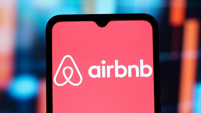 In this photo illustration, the Airbnb logo is seen 
