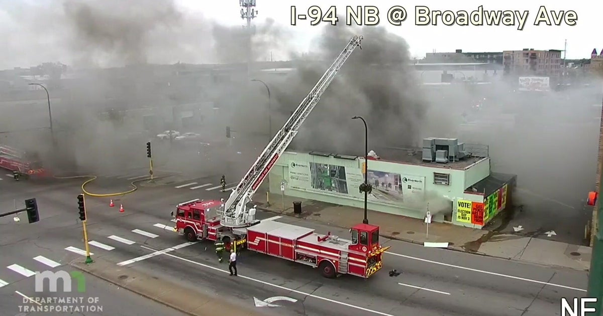 Firefighters battle blaze at north Minneapolis building on West Broadway Avenue, sending heavy smoke into air as crews respond