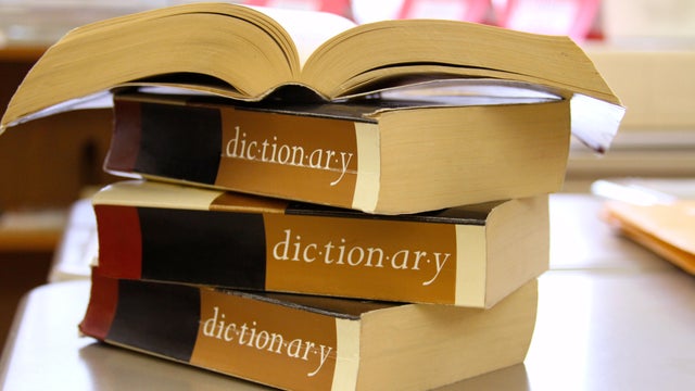 Stack of dictionaries on a desk 