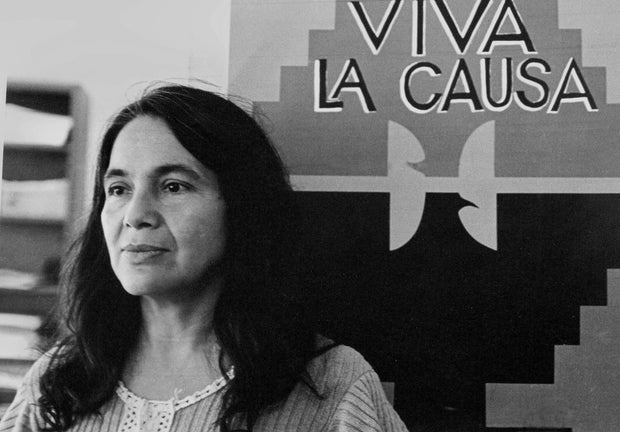 Dolores Huerta, co-founder of the United Farm Workers group, is seen with a union flag that reads "Viva La Causa" in the 1970s. 